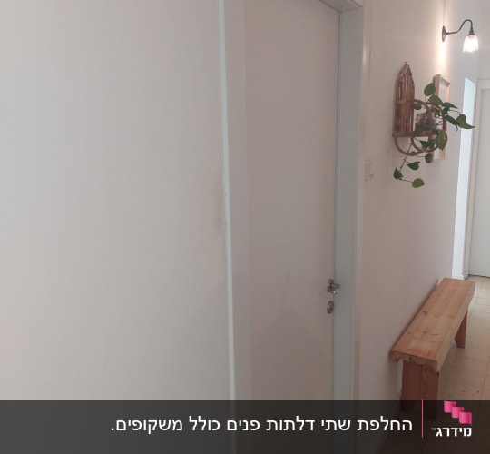 דלת לבנה עם ידית כסופה במסדרון מואר
